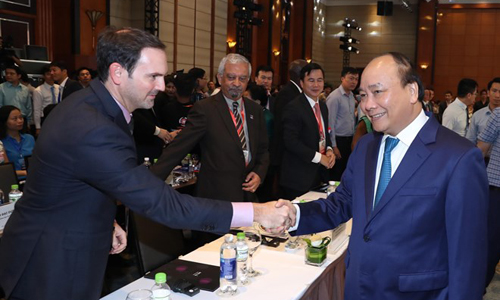 Prime Minister Nguyen Xuan Phuc (R) shakes hands with participants in the National Conference on Sustainable Development in Hanoi on July 5 (Photo: VNA)