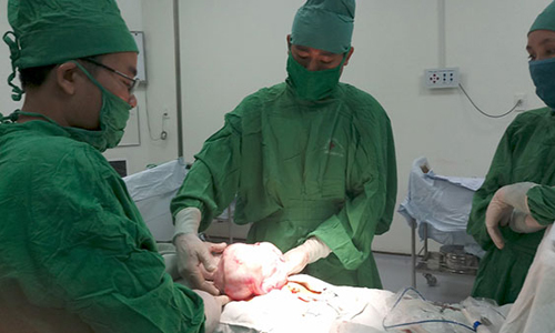 BS CKI Trương Xuân Định (người đứng giữa) và kíp phẫu thuật u nang buồng trứng cho bệnh nhân N.T.T. 46 tuổi, ngụ huyện Gò Công Tây,  tỉnh Tiền Giang