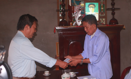 Đồng chí Nguyễn Ngọc Trầm tặng quà cho ông Trần Văn Sanh là thương binh (41%) ở ấp Tân Lợi, xã Tân Thới, huyện Tân Phú Đông.