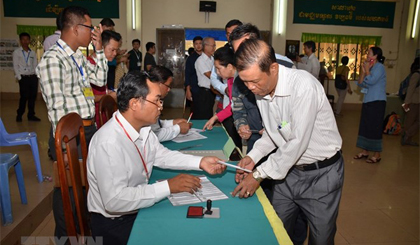 Cử tri làm thủ tục kiểm tra và nhận phiếu bầu tại phòng phiếu số 1697 ở thành phố Ta Khmau, tỉnh Kandal. Ảnh: TTXVN