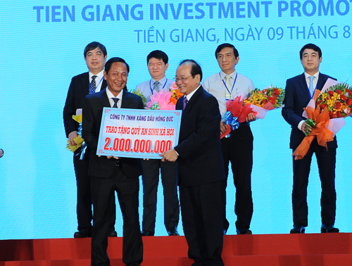 Đại diện doanh nghiệp trao bảng tượng trưng cho Quỹ an sinh xã hội tỉnh Tiền Giang