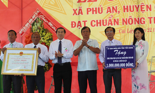 Đồng chí Lê Văn Hưởng và đồng chí Huỳnh Văn Phương trao Bằng công nhận và Bảng tượng trưng công trình phúc lợi 1 tỷ đồng cho xã Phú An.