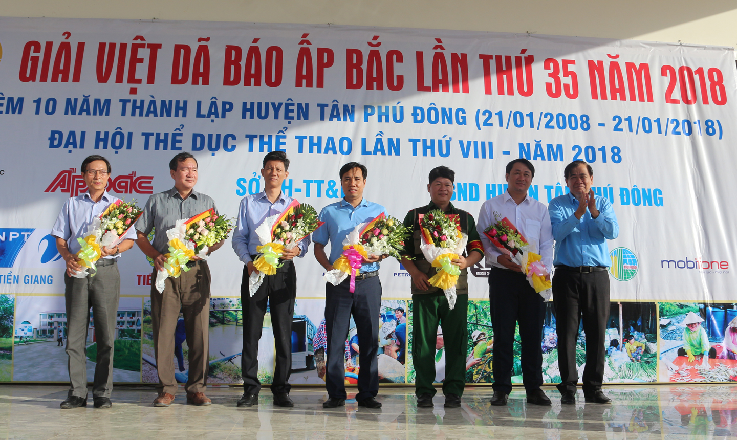 Giám đốc VNPT Tiền Giang Nguyễn Văn Thái, (người đứng thứ 2 từ trái sang), đơn vị tài trợ, nhận hoa từ Ban Tổ chức Giải Việt dã Báo Ấp Bắc lần thứ 35 - năm 2018. 