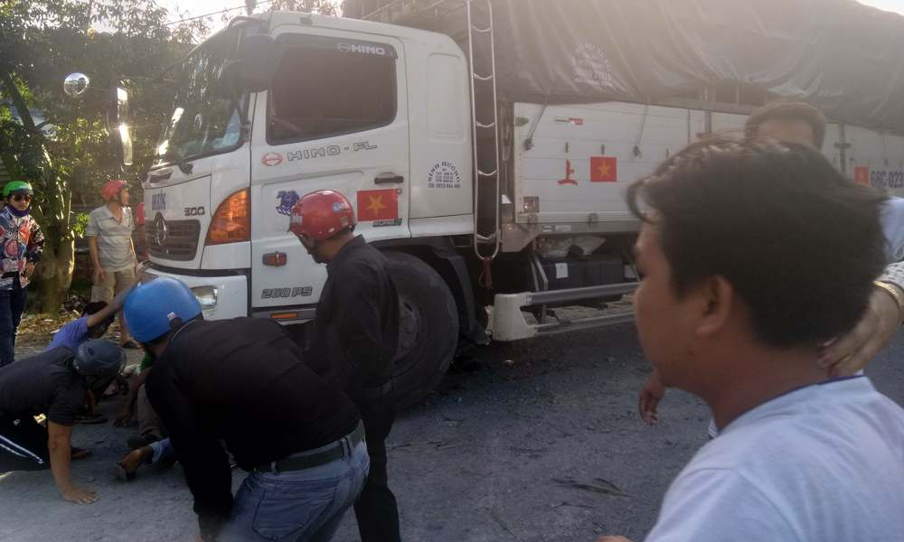 Người dân tham gia cứu người phụ nữ bị cuốn vào gầm xe tải sau tai nạn.