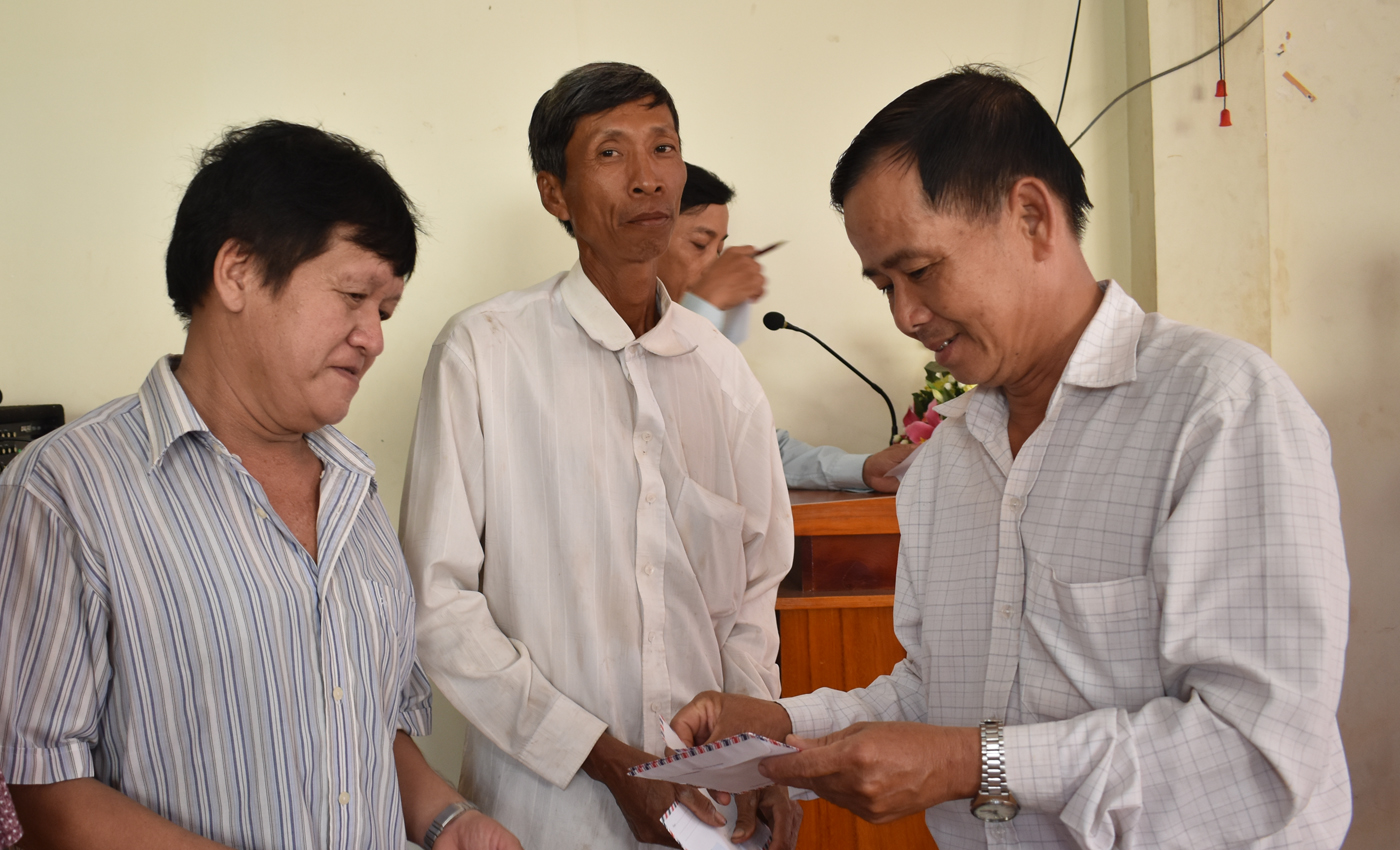 Đồng chí Trần Quang Linh, Phó Bí thư Huyện uỷ Chợ Gạo trao quà cho hộ nghèo