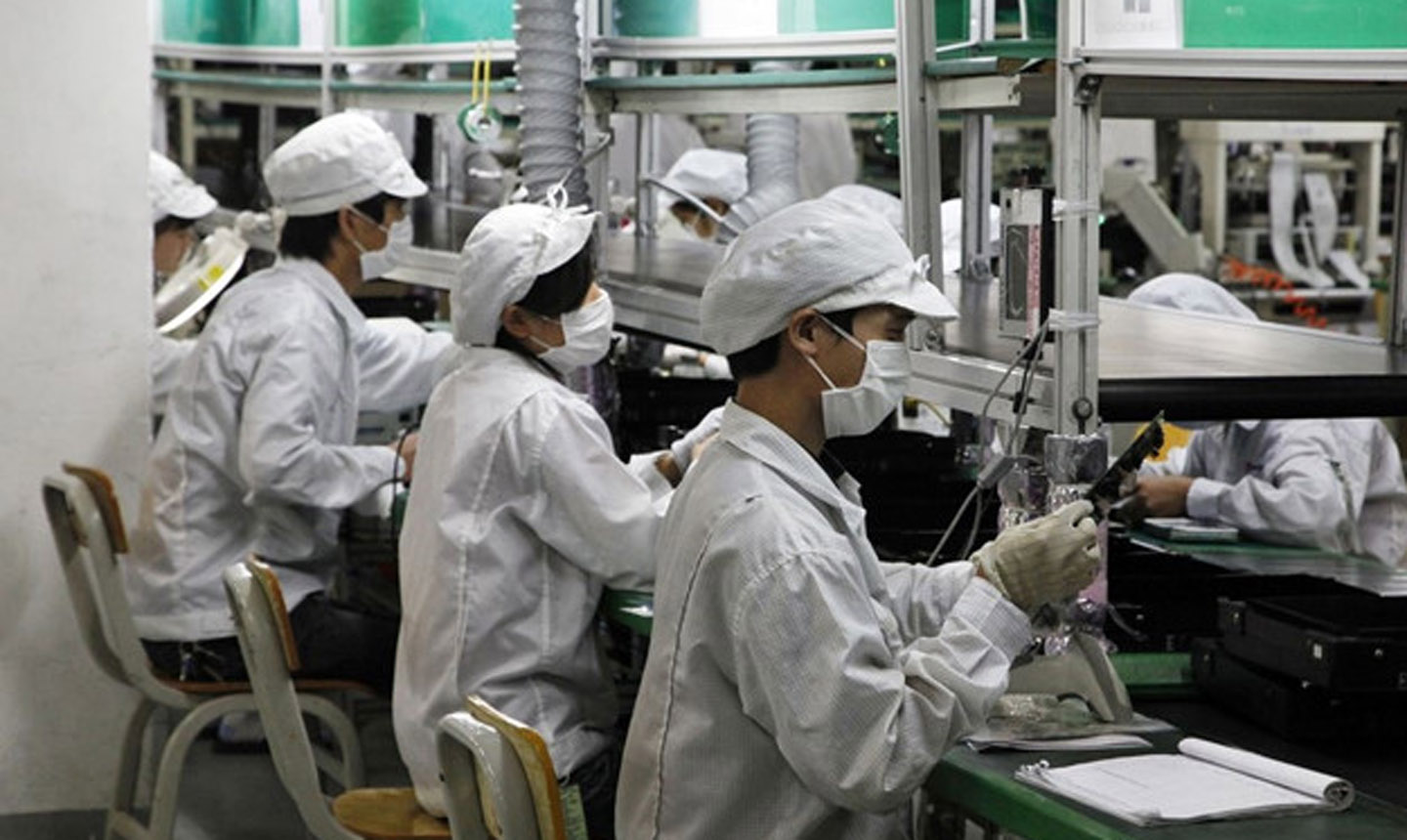 Các công nhân làm việc trên dây truyền lắp ráp của Foxconn. Ảnh: Bloomberg.