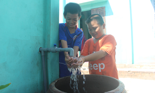 Nước sạch về trong niềm vui của các em nhỏ ở ấp Phú Hữu, xã Phú Tân.