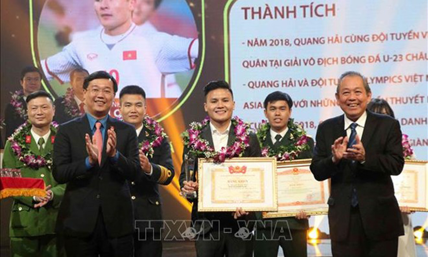  Deputy Prime Minister Truong Hoa Binh (R) presents the Outstanding Vietnamese Young Faces Award to fotballer Nguyen Quang Hai, the winner in the sports and physical training category (Photo: VNA)
