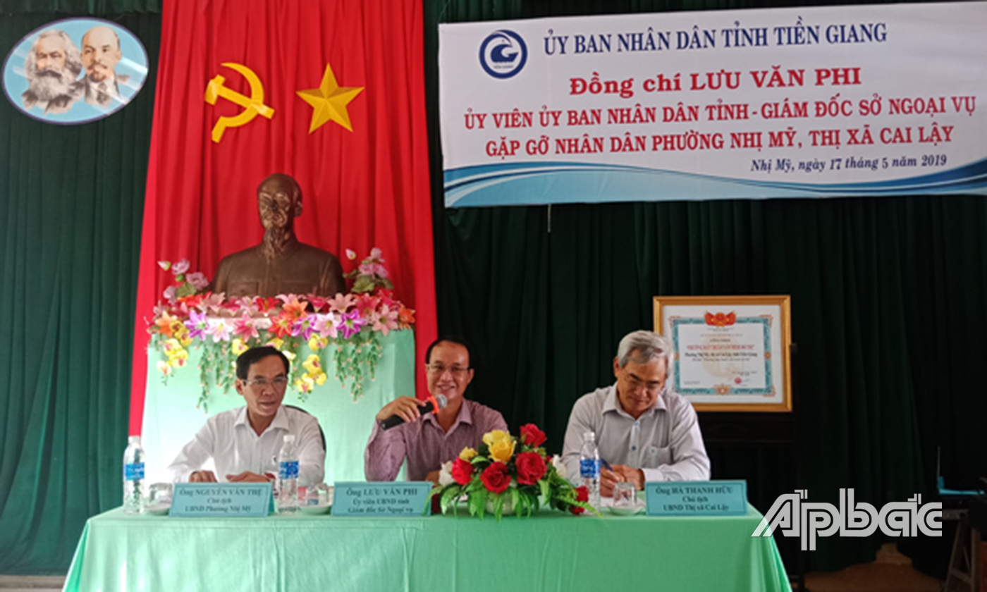 Đồng chí Lưu Văn Phi (ngồi giữa) gặp gỡ người dân ở phường Nhị Mỹ, thị xã Cai Lậy.