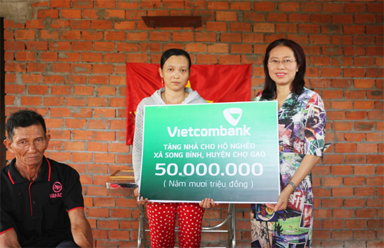 Bà Nguyễn Thị Tuyết, Giám đốc Vietcombank Tiền Giang trao biển biểu trưng cho gia đình bà Diễm.