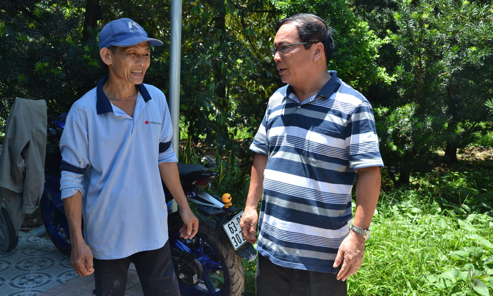 Đồng chí Phạm Anh Tuấn trao đổi với một chủ nuôi heo.