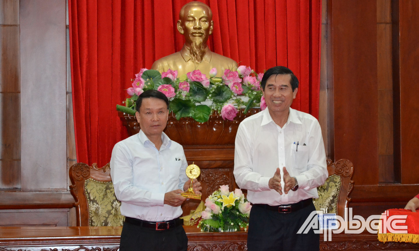 Chủ tịch UBND tỉnh Lê Văn Hưởng tặng quà lưu niệm cho Tổng Giám đốc Thông tấn xã Việt Nam Nguyễn Đức Lợi.
