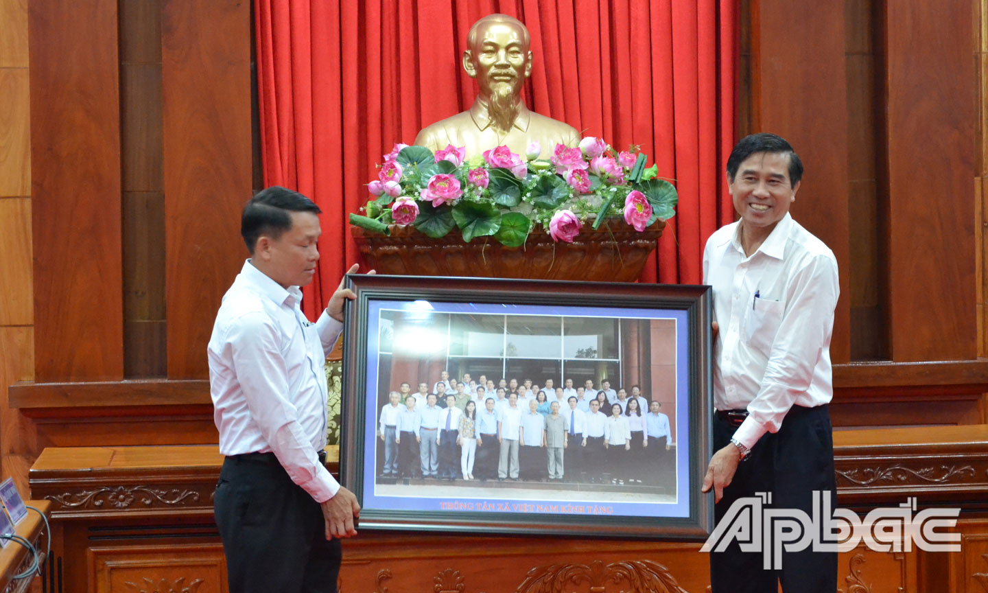 Tổng Giám đốc Thông tấn xã Việt Nam Nguyễn Đức Lợi tặng quà lưu niệm cho UBND tỉnh Lê Văn Hưởng.