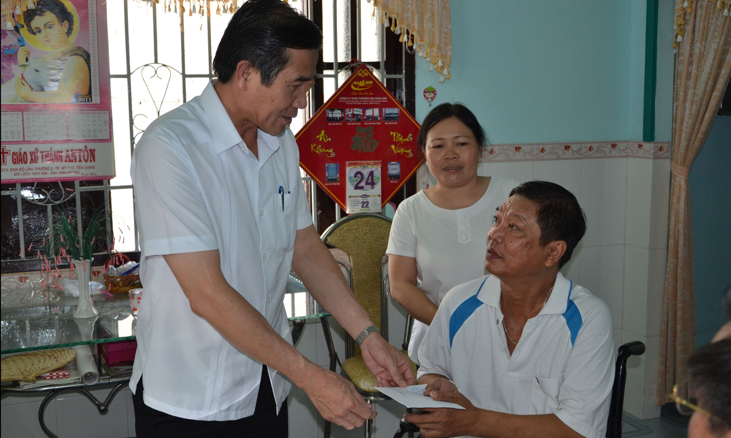Đồng chí Lê Văn Hưởng thăm, tặng quà gia đình thương binh Nguyễn Văn Hoa.