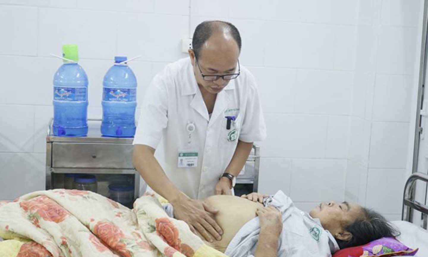 Phó giáo sư Đỗ Duy Cường khám cho một bệnh nhân điều trị viêm gan. (Ảnh: PV/Vietnam+)