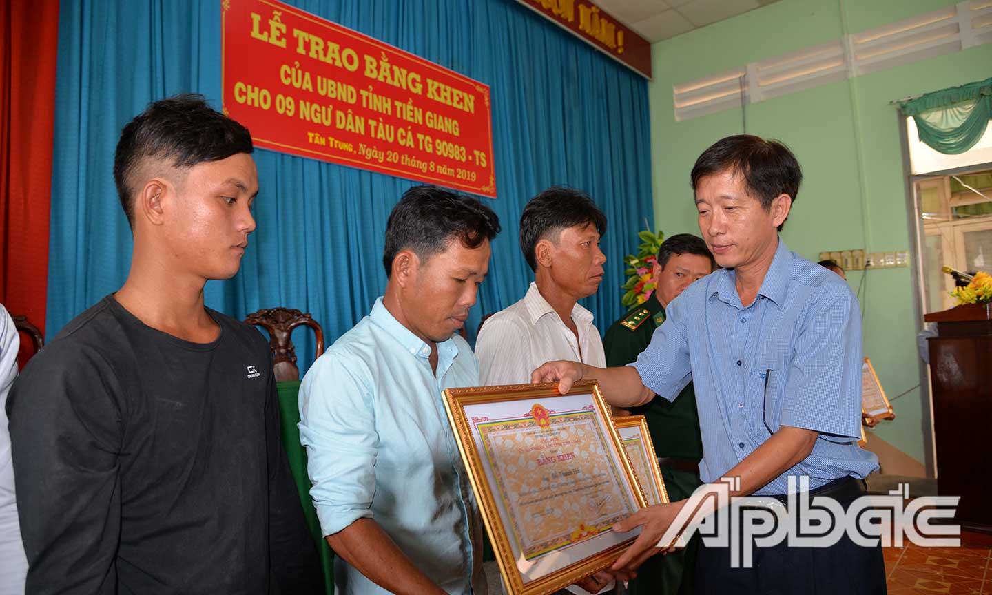 Đồng chí Trịnh Công Minh trao Bằng khen của UBND tỉnh cho thuyền trưởng và các ngư dân.