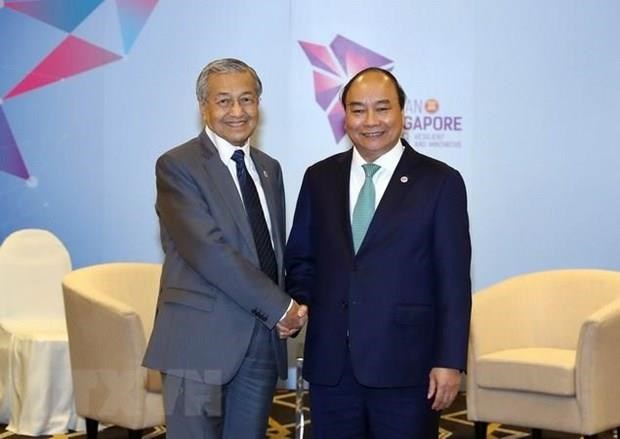 Prime Minister Nguyen Xuan Phuc (R) shakes hands with Malaysian Prime Minister Mahathir Mohamad  during the 33rd ASEAN Summit and related meetings in Singapore (Photo: VNA)