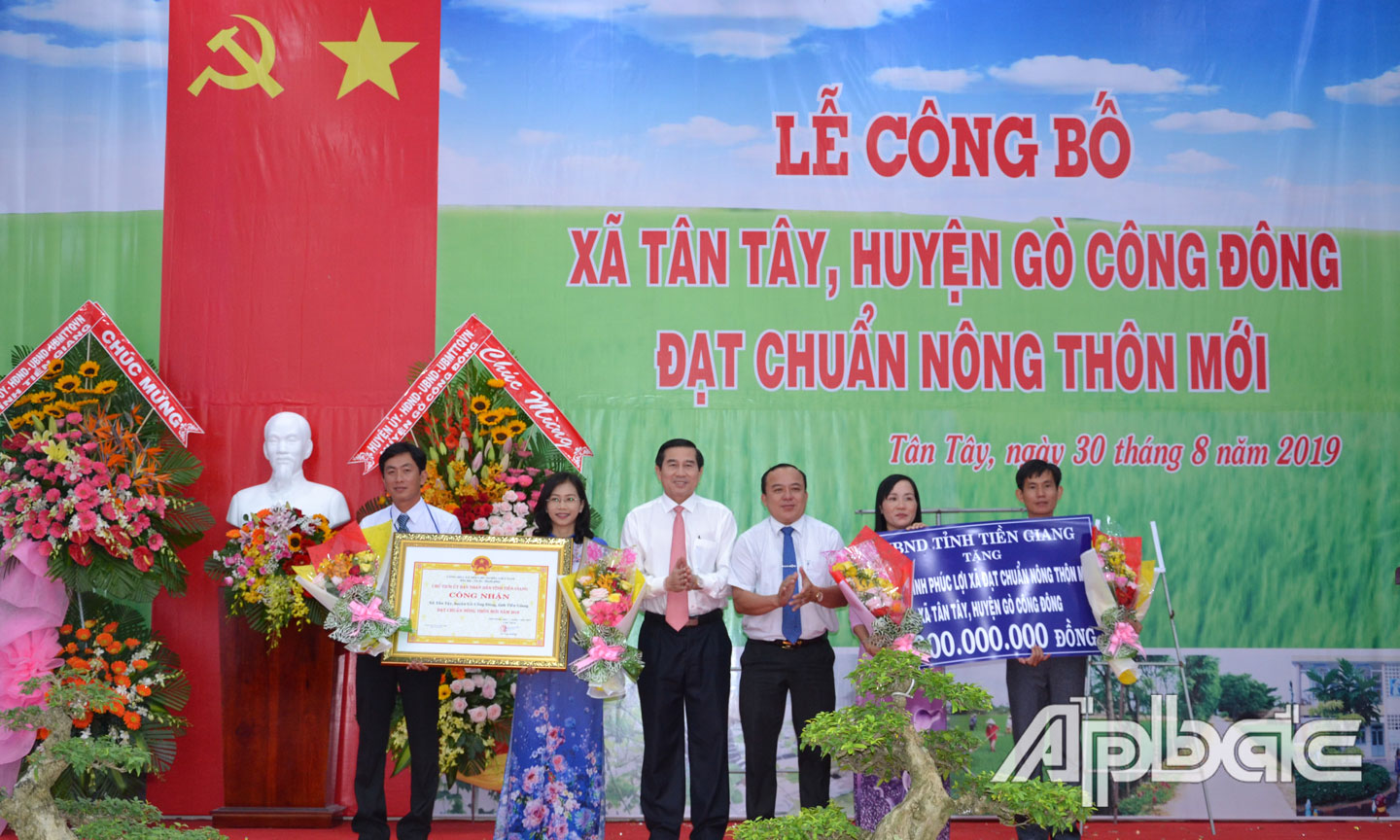 Chủ tịch UBND tỉnh Lê Văn Hưởng trao Bằng công nhận xã Tân Tây đạt chuẩn NTM và bảng tượng trưng công trình phúc lợi.