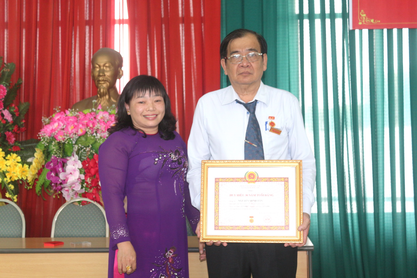 Đồng chí Thái Ngọc Bảo Trâm trao Huy hiệu 30 năm tuổi đảng cho đồng chí Nguyễn Minh Tân. Ảnh: HỒNG LÊ