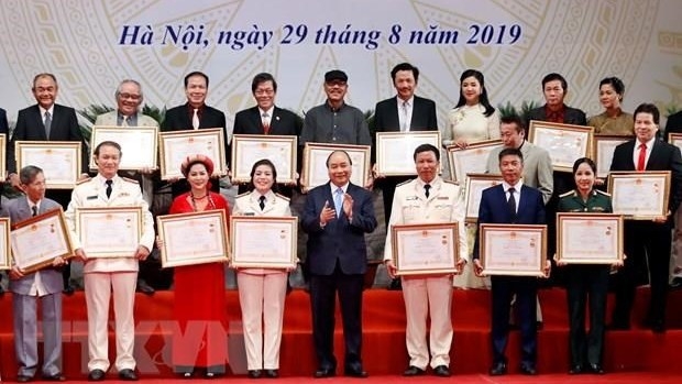 Prime Minister Nguyen Xuan Phuc (fourth from right, front row) and the outstanding artists (Photo: VNA)