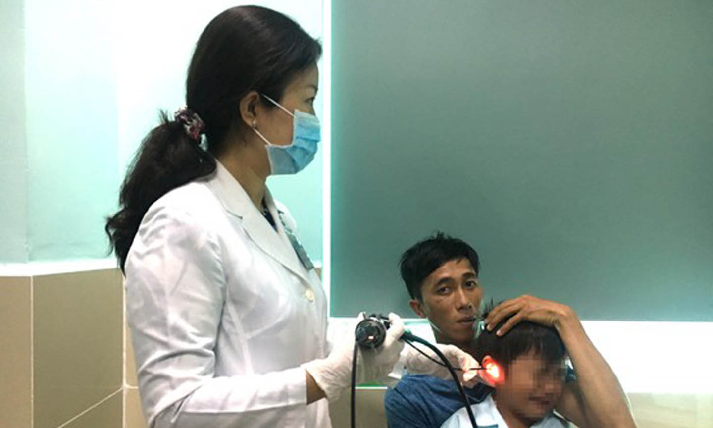 Bác sĩ kiểm tra tai của bệnh nhi T.T.Đ sau khi nội soi gắp được viên pin