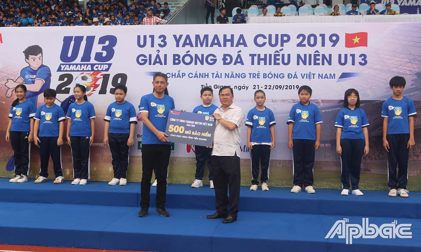 Đại diện Yamaha Việt Nam trao Ban An toàn Giao thông tỉnh Tiền Giang bảng tượng trưng tặng 500 nón bảo hiểm cho học sinh đến Ba