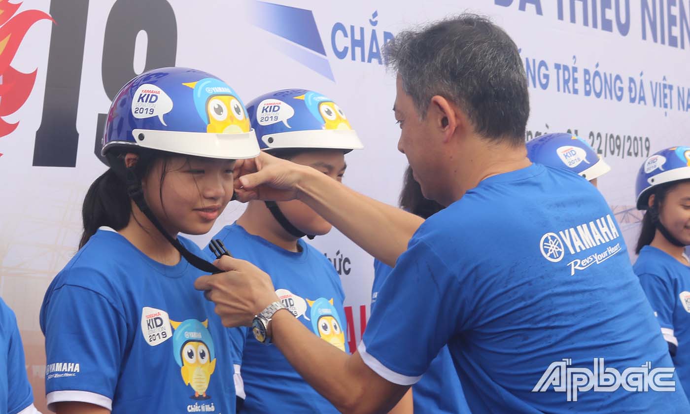 Đại diện Ban An toàn Giao thông tỉnh Tiền Giang, Yamaha Việt Nam trao nón bảo hiểm cho các em học sinh.