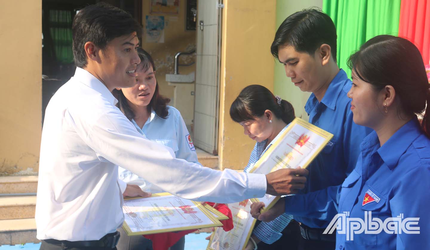 Anh Nguyễn Quang Minh trao bằng khen của Hội Đồng đội Trung ương cho các tập thể có thành tích xuất sắc tring năm học 2018 - 2019.