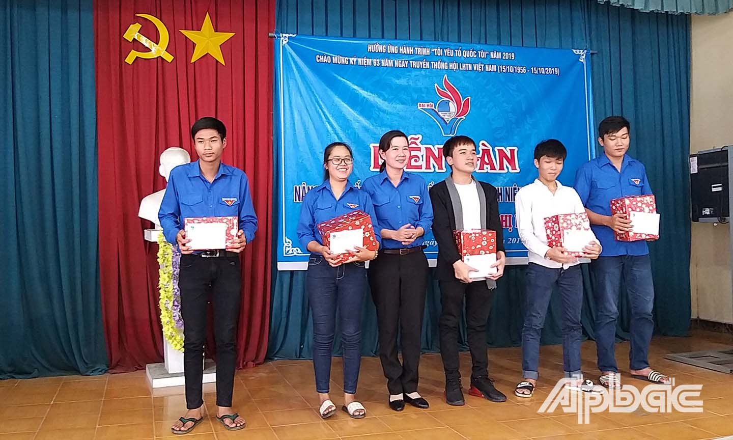 Chị Nguyễn Thị Mỹ Nương trao quà cho các thanh niên tôn giáo ở xã Long Định, huyện Châu Thành.