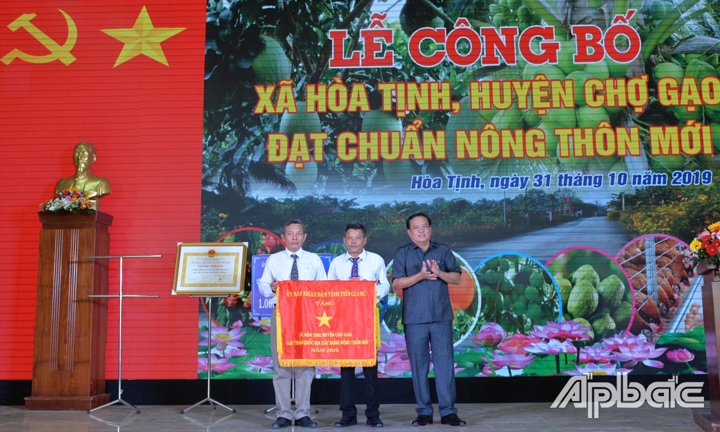 Đồng chí Lê Văn Nghĩa cờ thi đua của UBND tỉnh cho xã Hòa Tịnh.