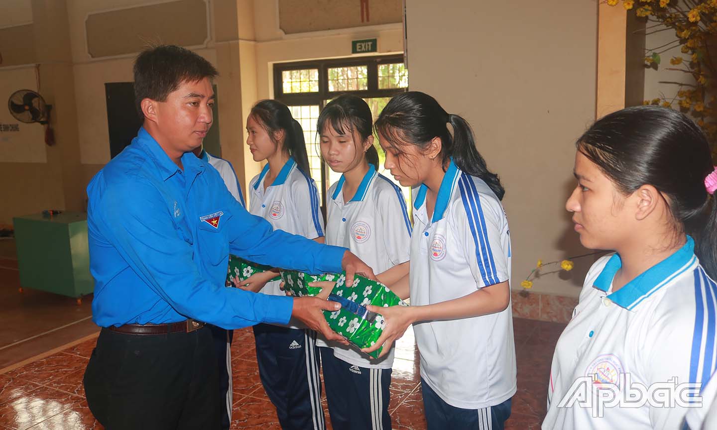 Anh Phạm Văn Toàn, Trưởng Ban Tuyên giáo Tỉnh đoàn, tặng quà cho các em học sinh ở Trường THPT Vĩnh Bình.