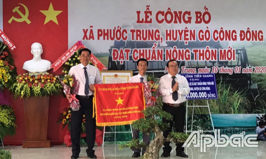 Đồng chí Phạm Anh Tuấn trao Cờ thi đua của UBND tỉnh cho xã đạt chuẩn NTM Phước Trung.
