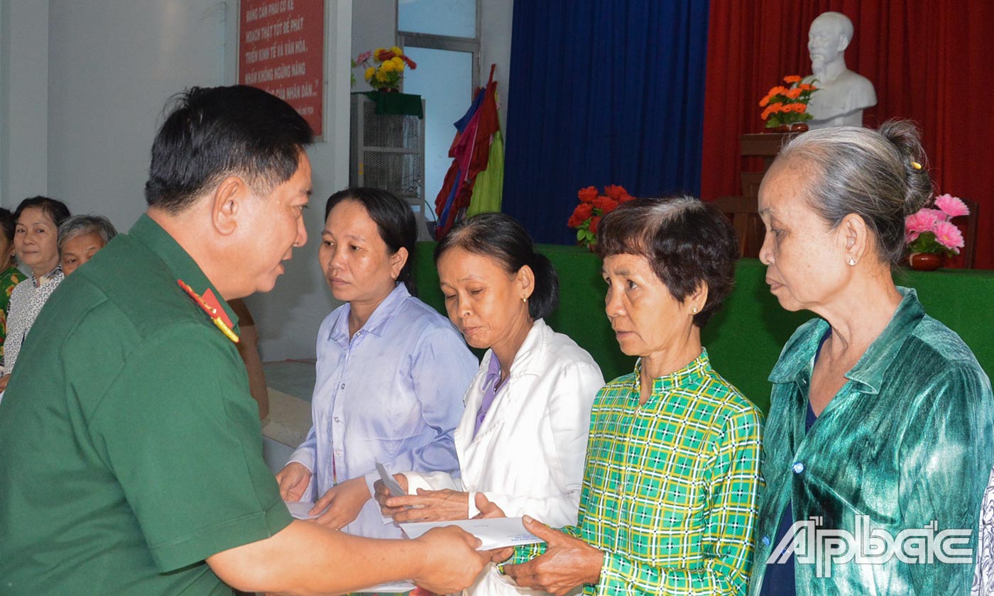 Đại tá Châu Hoàng Phương trao quà cho các hộ nghèo của xã Bình Phú.