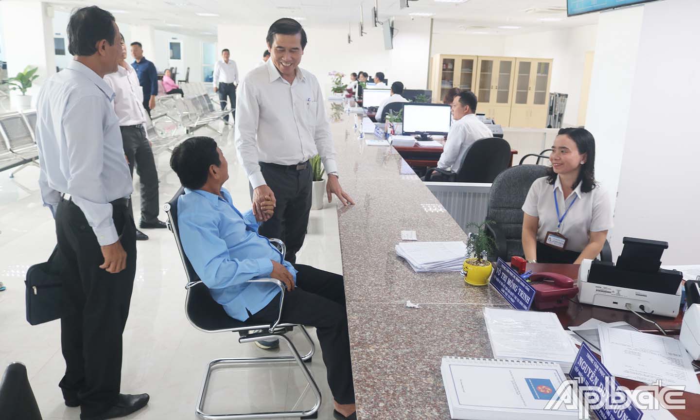 Đồng chí Lê Văn Hưởng trao đổi với người dân đến làm thủ tục tại Trung tâm phục vụ hành chính công.