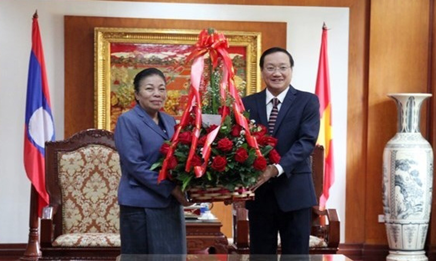 Sounthone Sayachak (L), head of the LPRP Central Committee’s Commission for External Relations, presents congratulations flowers to Vietnam’s Ambassador to Laos Nguyen Ba Hung on February 3 (Photo: VNA)