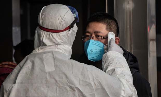 Kiểm tra thân nhiệt một hành khách nhằm ngăn chặn sự lây lan của dịch viêm đường hô hấp cấp do virus corona chủng mới (2019-nCoV) tại nhà ga đường sắt ở Bắc Kinh, Trung Quốc ngày 27/1/2020. (Ảnh: THXTTXVN)