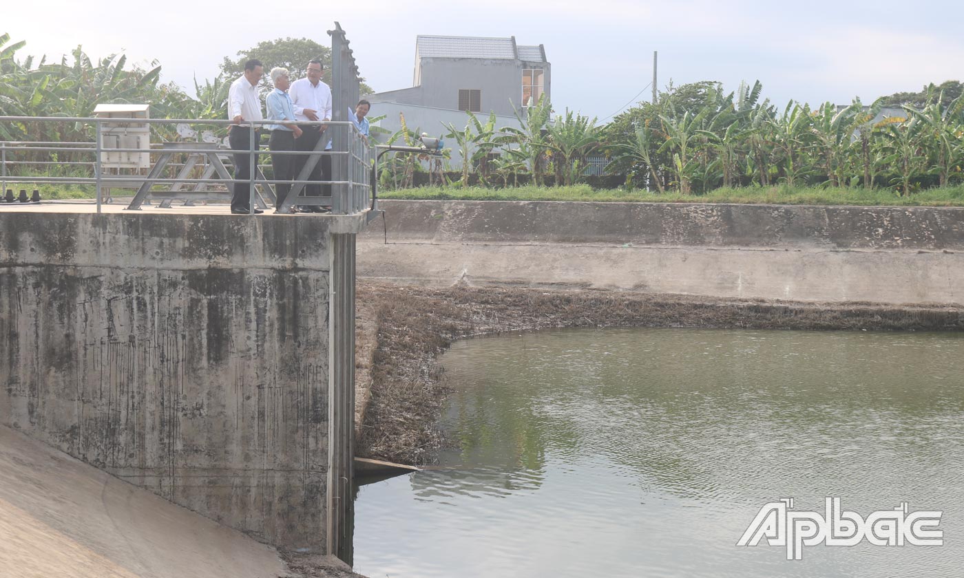 Đồng chí Lê Văn Nghĩa (ảnh trên, bia phải) đến kiểm tra ao chứa trữ nước của Nhà máy nước Đồng Tâm.