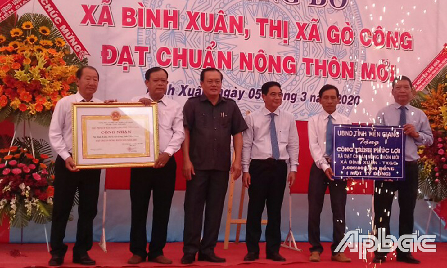 Comrade Le Van Nghia an Nguyen Chi Trung present the certificates of recognition and the one billion VND welfare work to Gia Thuan commune.awarded the certificate of recognition of NTM standard and the symbolic table of donation of a VND 1 billion welfare project to Binh Xuan commune.