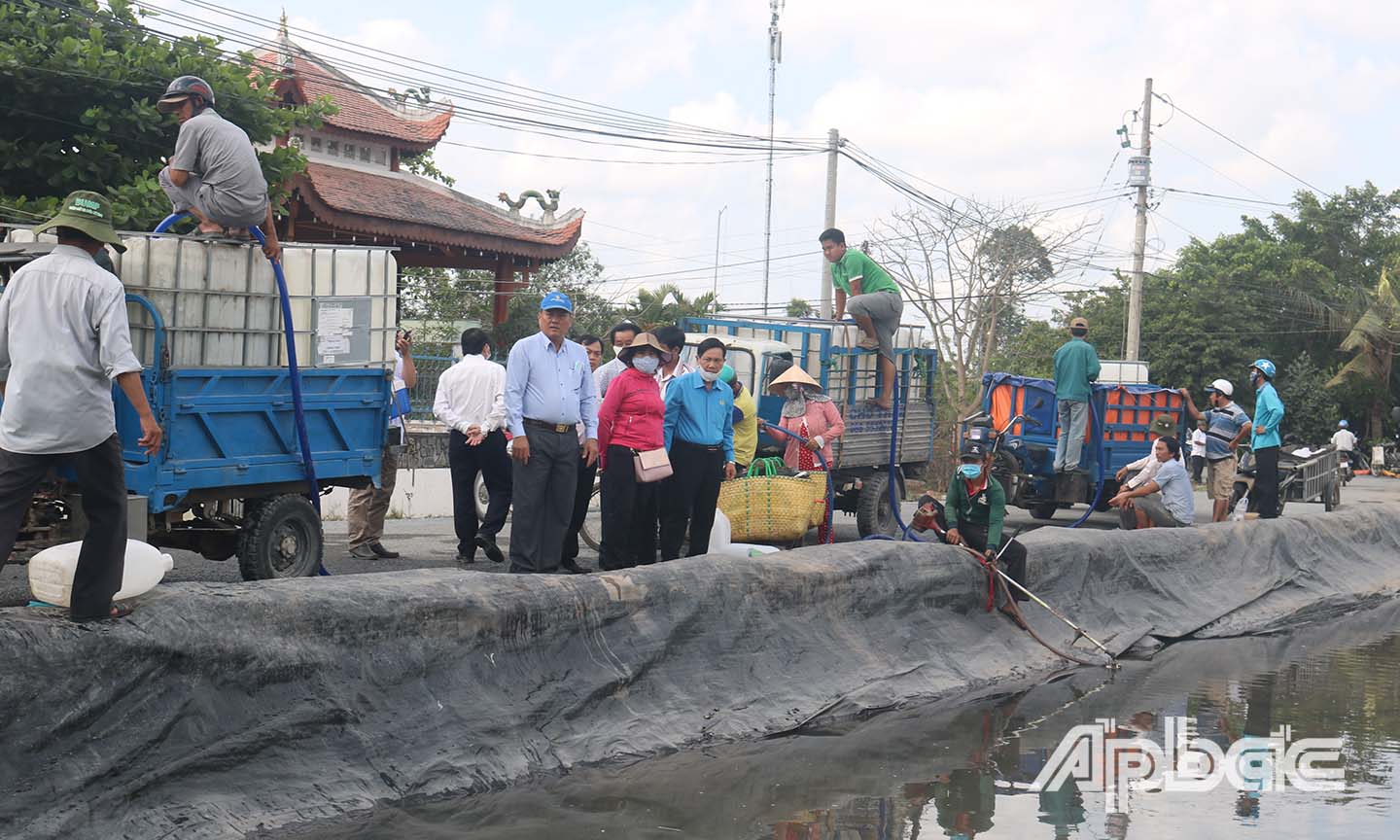 Nhiều xe xếp hàng lấy nước miễn phí  tại ao bạt ở xã Cẩm Sơn, huyện Cai Lậy.