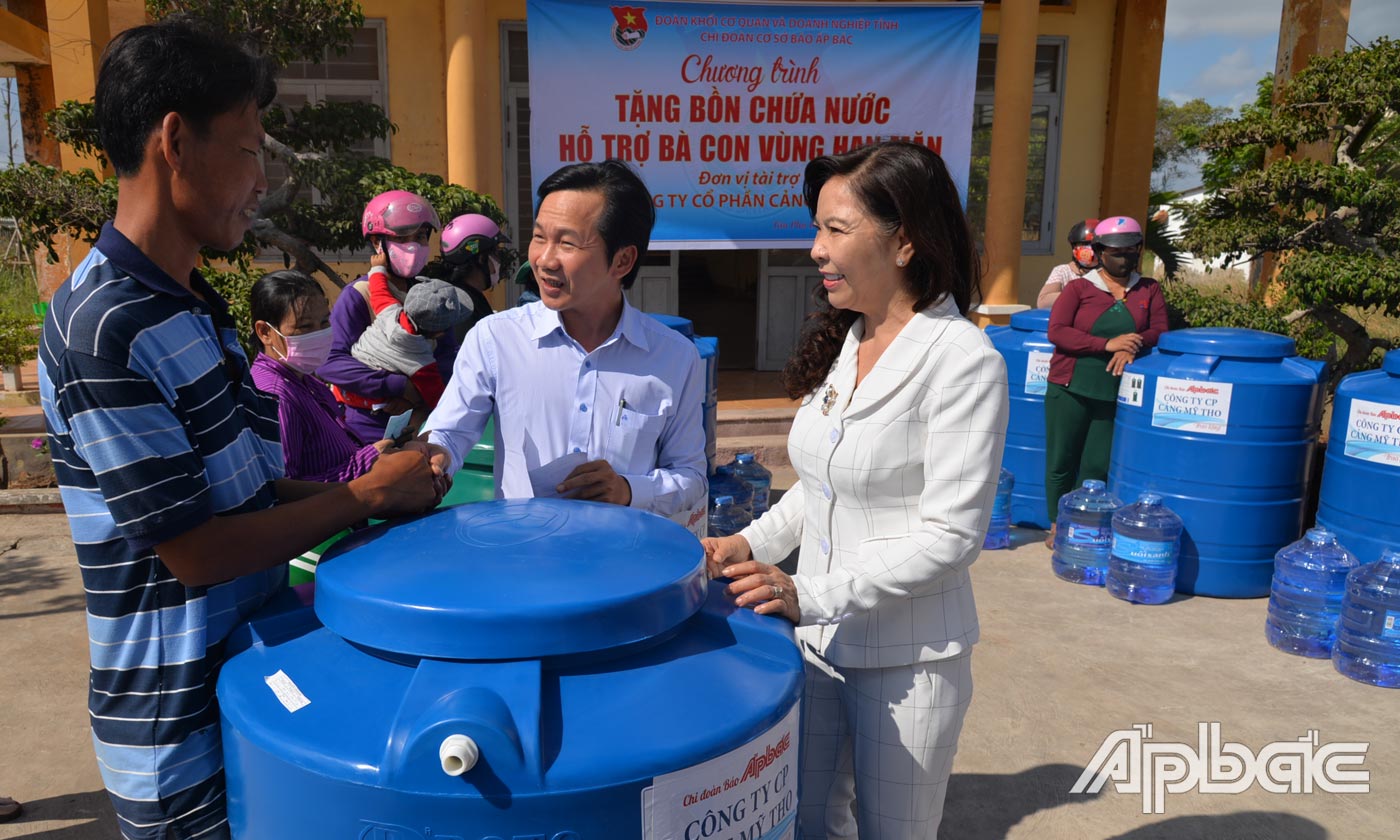 Phó Tổng Biên tập Báo Ấp Bắc Nguyễn Trọng Tấn và bà Lương Thị Diễm Trang (bìa phải) trao tặng bồn chứa nước sạch cho người dân có hoàn cảnh khó khăn ở xã Phú Tân.