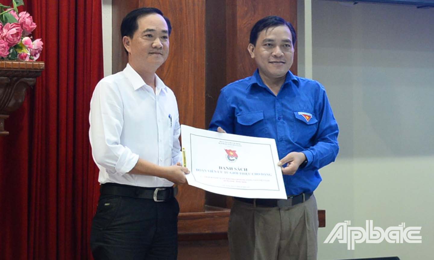 Anh Ngô Huỳnh Quang Thái (bên phải) trao danh sách giới thiệu đoàn viên ưu tú cho Đảng xem xét kết nạp đến lãnh đạo Ban Tổ chức Tỉnh ủy.