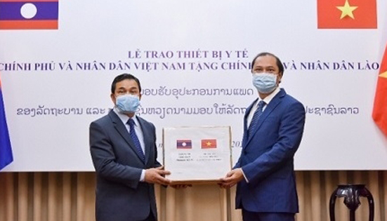 Deputy Foreign Minister Nguyen Quoc Dung (R) presents the gift to Lao Ambassador to Vietnam Sengphet Houngboungnuang (Photo: MOFA)