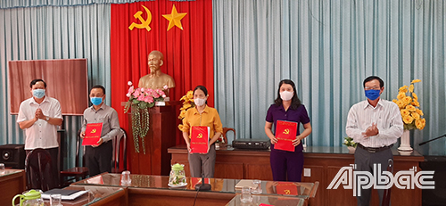 Đồng chí Nguyễn Hữu Lợi (bìa trái) và đồng chí Trần Văn Trí, Phó Bí thư Thường trực Thị ủy Gò Công trao Quyết định cho cán bộ.