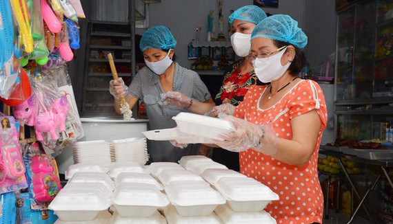  A family in HCM City prepares food portions free of charge for poor people and hospital staff (Photo: www.sggp.org.vn)