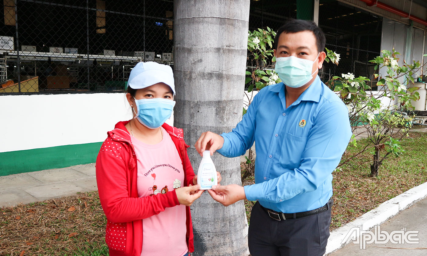 Công nhân lao động tại Công ty TNHH Dụ Đức Việt Nam nhận nước rửa tay sát khuẩn từ Chủ tịch Công đoàn cơ sở công ty.
