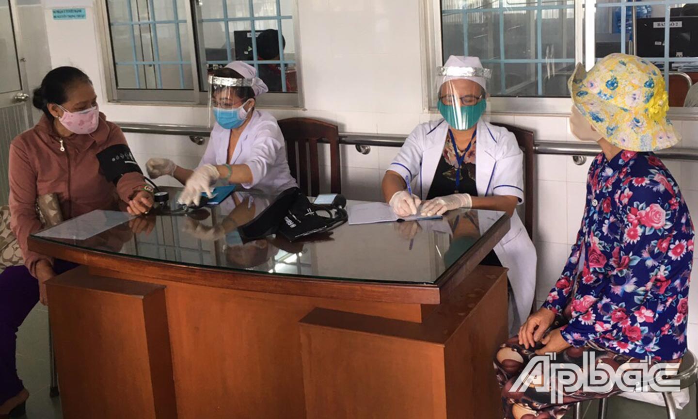 Nhân viên y tế của TTYT huyện Cái Bè trang bị đầy đủ công cụ phòng, chống dịch Covid-19 khi thăm khám bệnh nhân. 