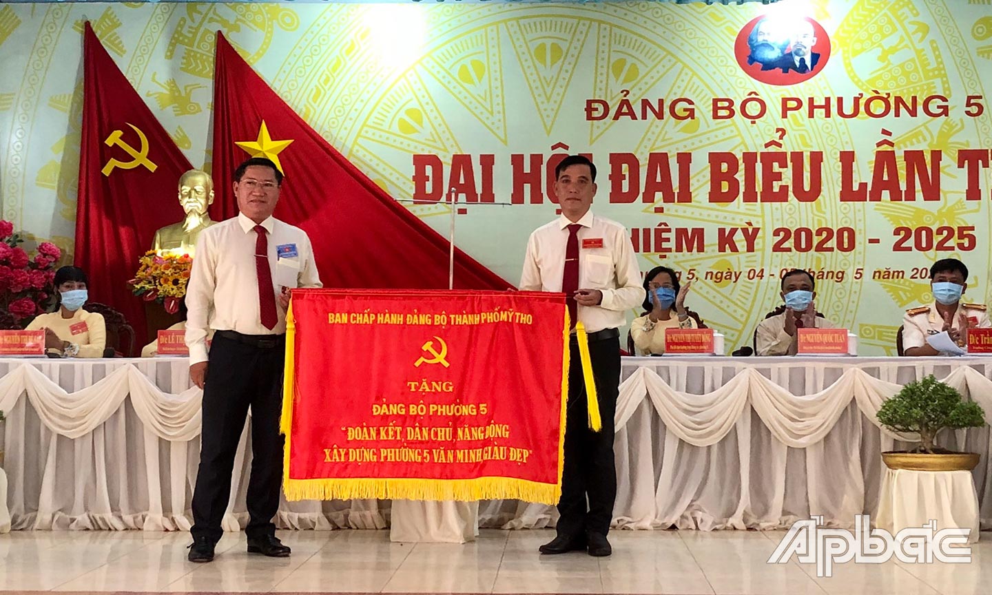 Đồng chí Đặng Thanh Liêm (bên trái) trao bức trướng của Ban Chấp hành Đảng bộ TP. Mỹ Tho tặng Đảng bộ phường 5 với dòng chữ “Đoàn kết, dân chủ, năng động xây dựng phường 5 văn minh, giàu đẹp”.