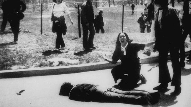 A student of Kent State University cries out and gestures as she kneels over the body of another student killed in the shooting (Photo: CNN)