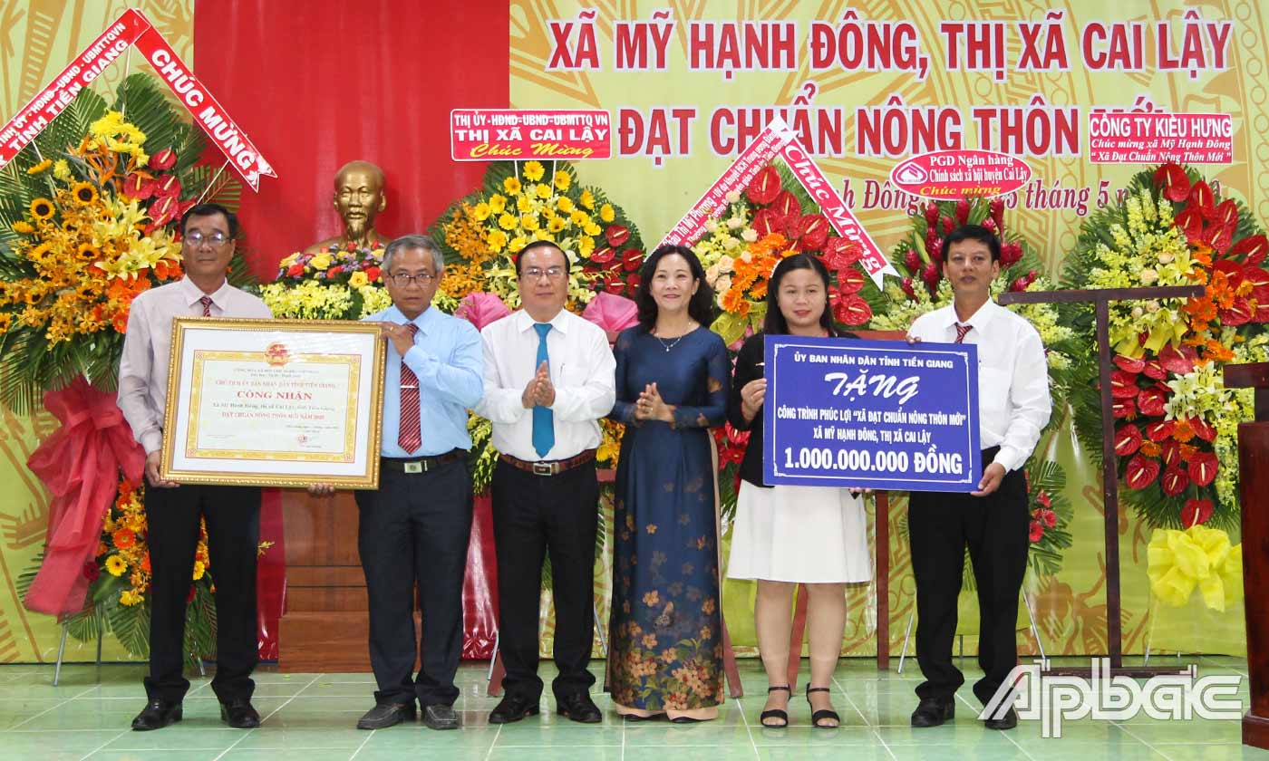 Đồng chí Nguyễn Thị Sáng và đồng chí Phạm Anh Tuấn trao Bằng Công nhận đạt chuẩn xã NTM và tặng bảng tượng trưng công trình phúc lợi trị giá 1 tỷ đồng cho xã Mỹ Hạnh Đông.