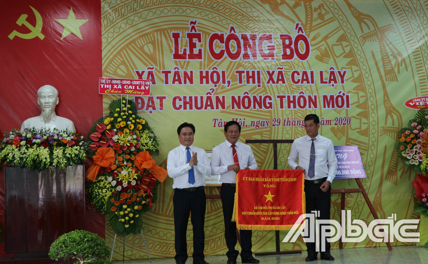 Đồng chí Trần Văn Dũng trao Bằng Công nhận đạt chuẩn NTM và tặng Cờ thi đua cho Đảng bộ, chính quyền và nhân dân xã Tân Hội 
